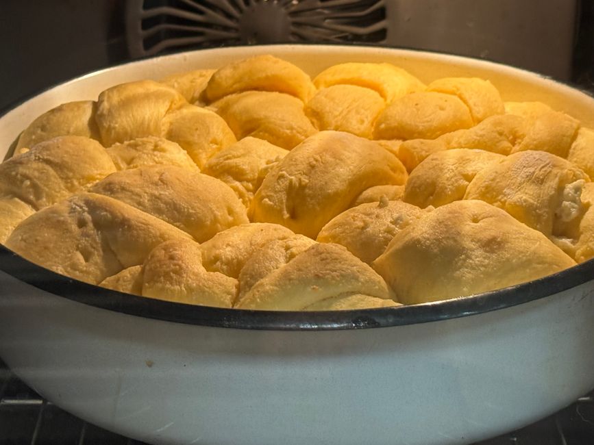 Close-up of fluffy, golden dinner rolls baking in the oven, showcasing a warm and inviting atmosphere.